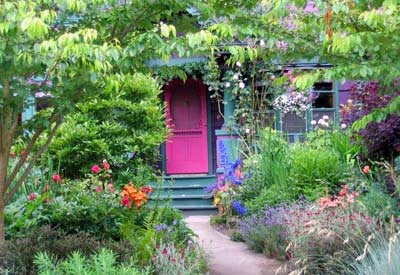house with a garden in the front of it next to the walkway