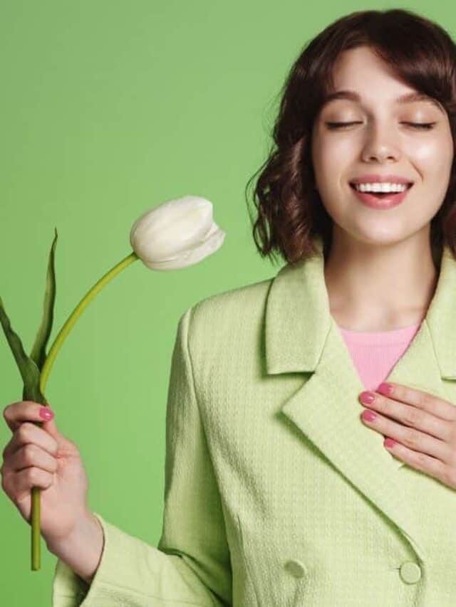 Woman smelling white flower.