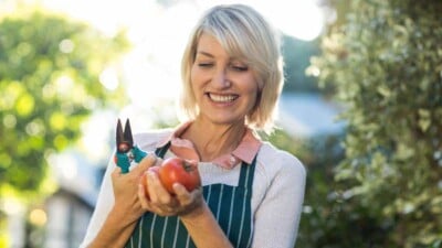 happy female gardener holding pruning shears