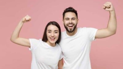 Man and woman, smiling and flexing their muscles