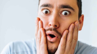 Man looking scared with hands on his face