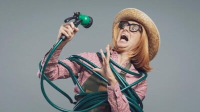 Woman gardener tied up with garden hose shouting