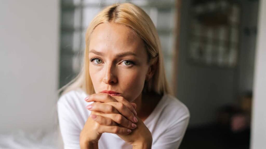 Woman looking concerned with hands folded