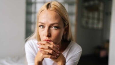 Woman looking concerned with hands folded