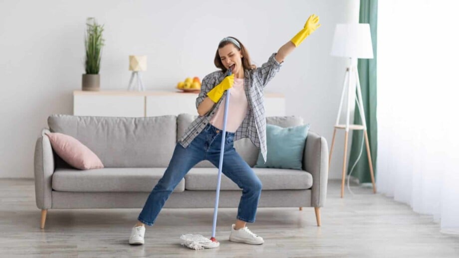 Woman singing into mop handle