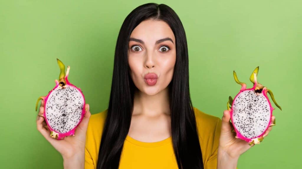 Woman holding dragon fruit from dragon fruit plant