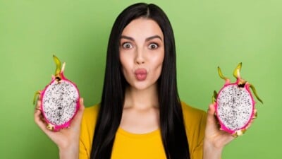 Woman holding dragon fruit from dragon fruit plant