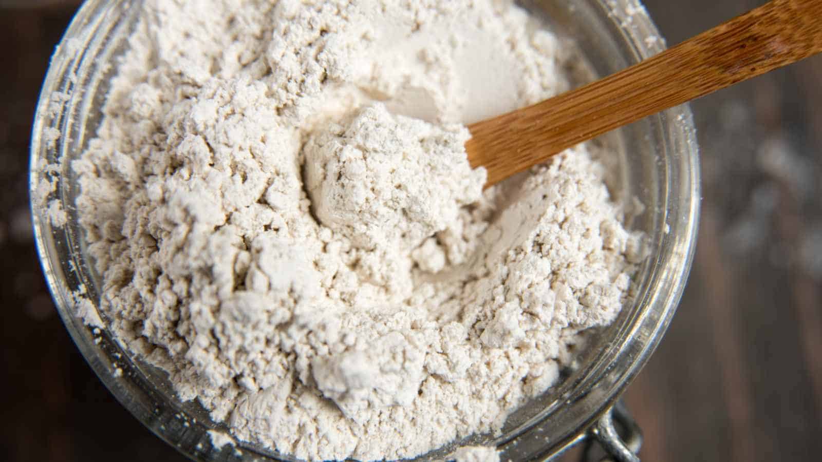 Diatomaceous earth in glass container with a wooden spoon