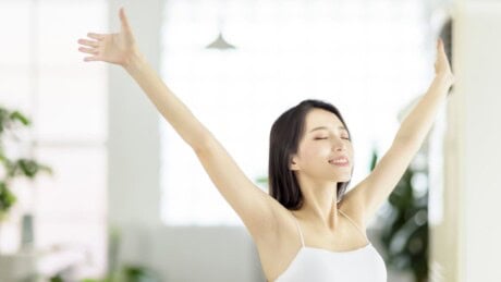Young asian woman happily breathing in fresh air