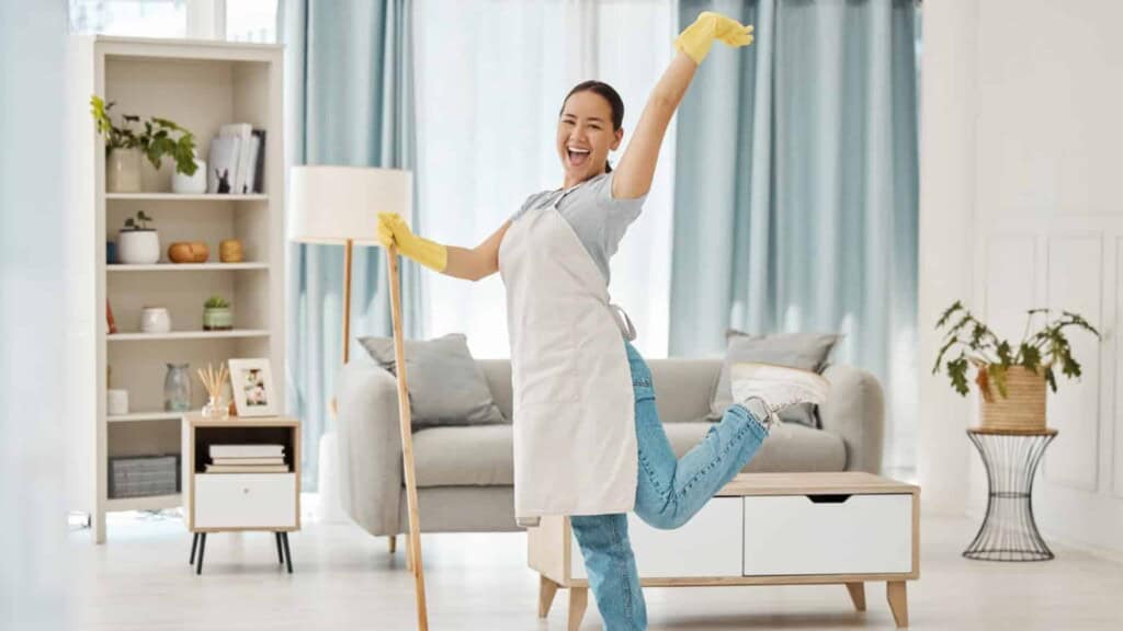 Happy Asian woman cleaning her house with a mop