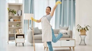 Happy Asian woman cleaning her house with a mop