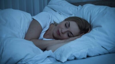 Young Woman With Blanket Sleeping In Bed.