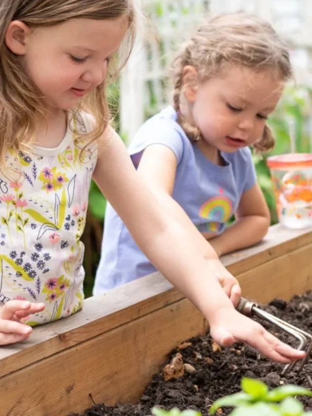 2 young girls gardening in a raised bed garden