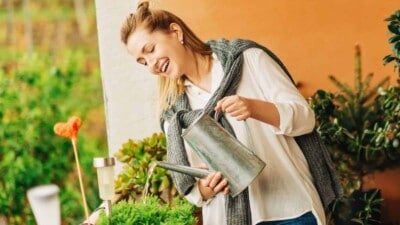 Woman watering her container garden on her balcony